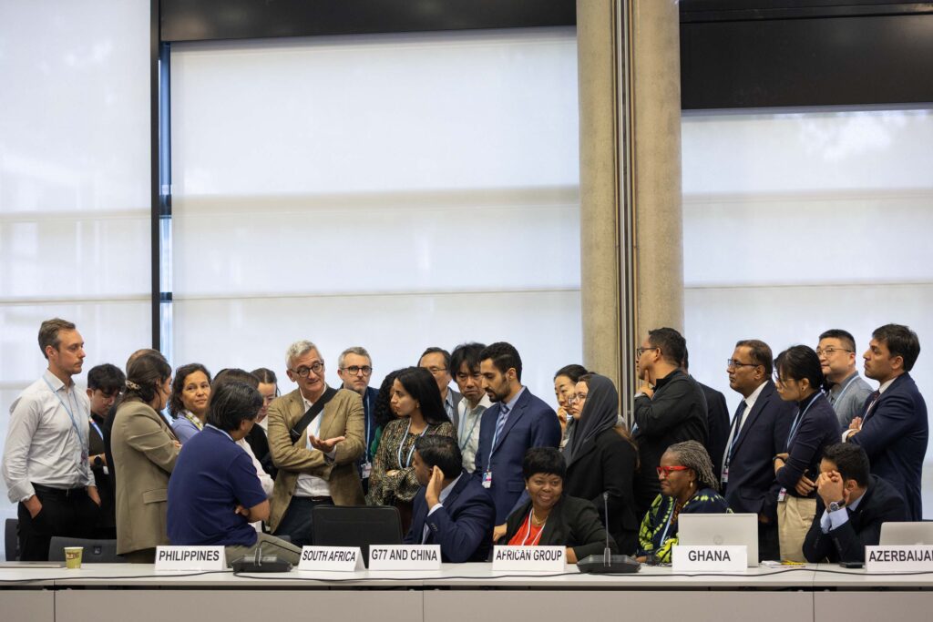 Delegates Huddle During Informal Consultations on Response Measures. Source: IISD/ENB - Kiara Worth